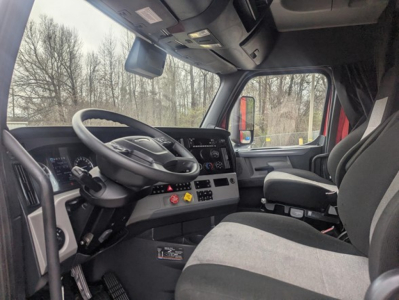Cab interior of a 2022 Freightliner Cascadia 126 conventional sleeper showing steering wheel, dashboard with digital gauges, center console, and driver's seat