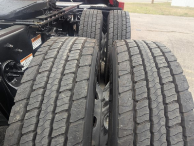 Freightliner Cascadia 126 trucks showing dual rear axles and treaded tires.