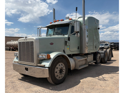 Peterbilt 378 UltraCab conventional sleeper truck in light green, front three-quarter view showing large grille, dual exhaust stacks, and tandem rear axles.