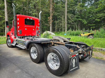 Kenworth T880 chassis with red sleeper cab, multiple rear axles, and chrome wheels; flatbed/matching frame visible; VIN and stock number not visible in image.