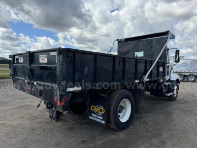 Dump truck in a yard showing a Mack MD dump bed with raised bed and rear tailgate. Visible labels include CARCO TRUCK SALES on mudflap and truck body; no other legible text clearly visible.