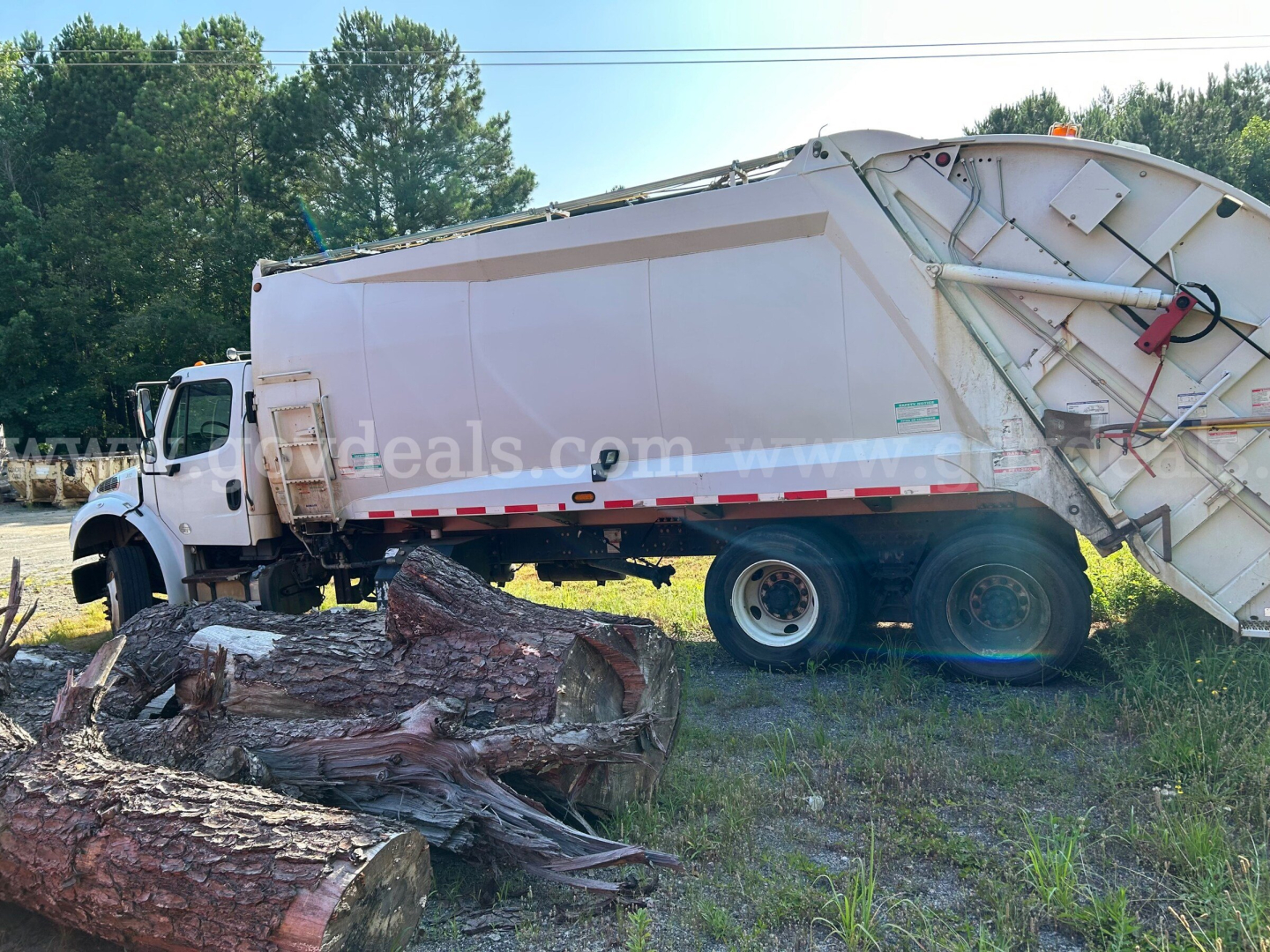 Dump truck body of a 2013 Freightliner M2 106 with a white dump bed and damaged front wheel area, VIN 1FVHCYBS7DHFB9919 visible.