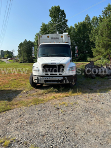 Front view of a white Freightliner M2 106 dump truck with McNeilus box, used condition, VIN 1FVHCYBS7DHFB9919, stock 790-335, on gravel lot.