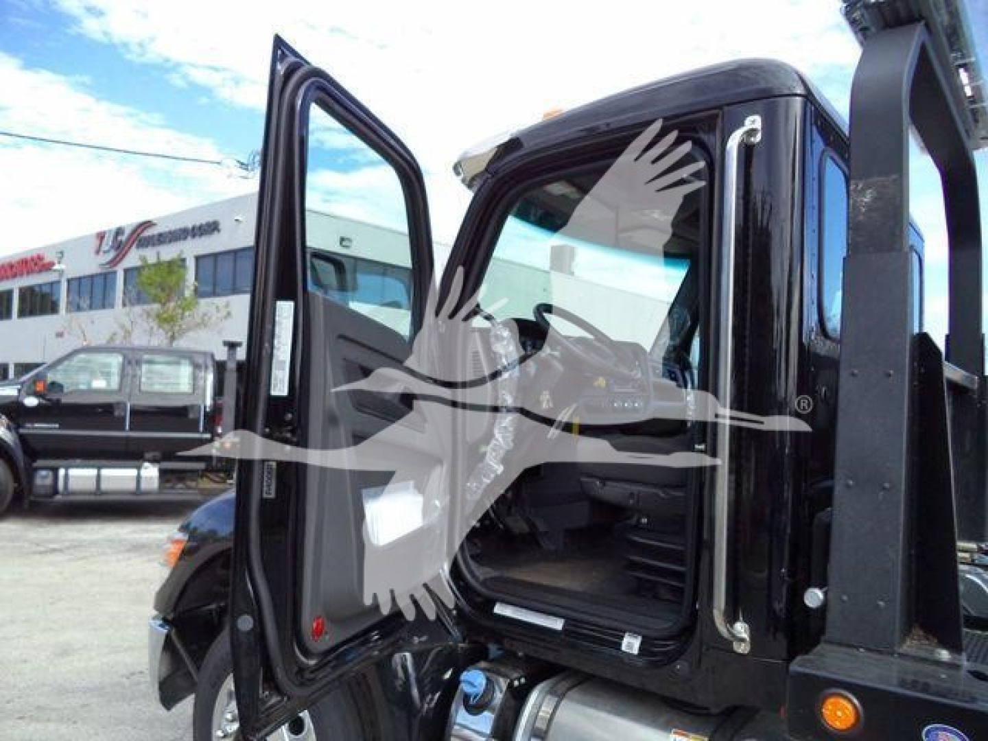 Kenworth T280 cab interior with doors open, showcasing driver seat and entry area for a rollback truck