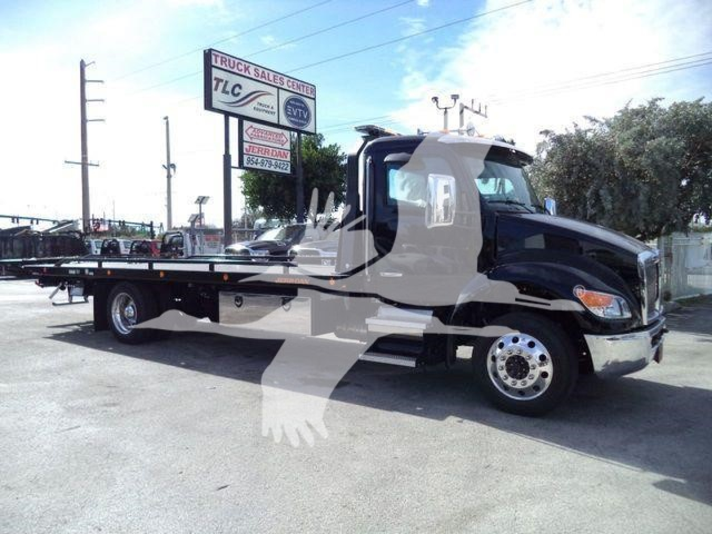 Kenworth T280 rollback truck side view showing flatbed and cab with chrome wheels.