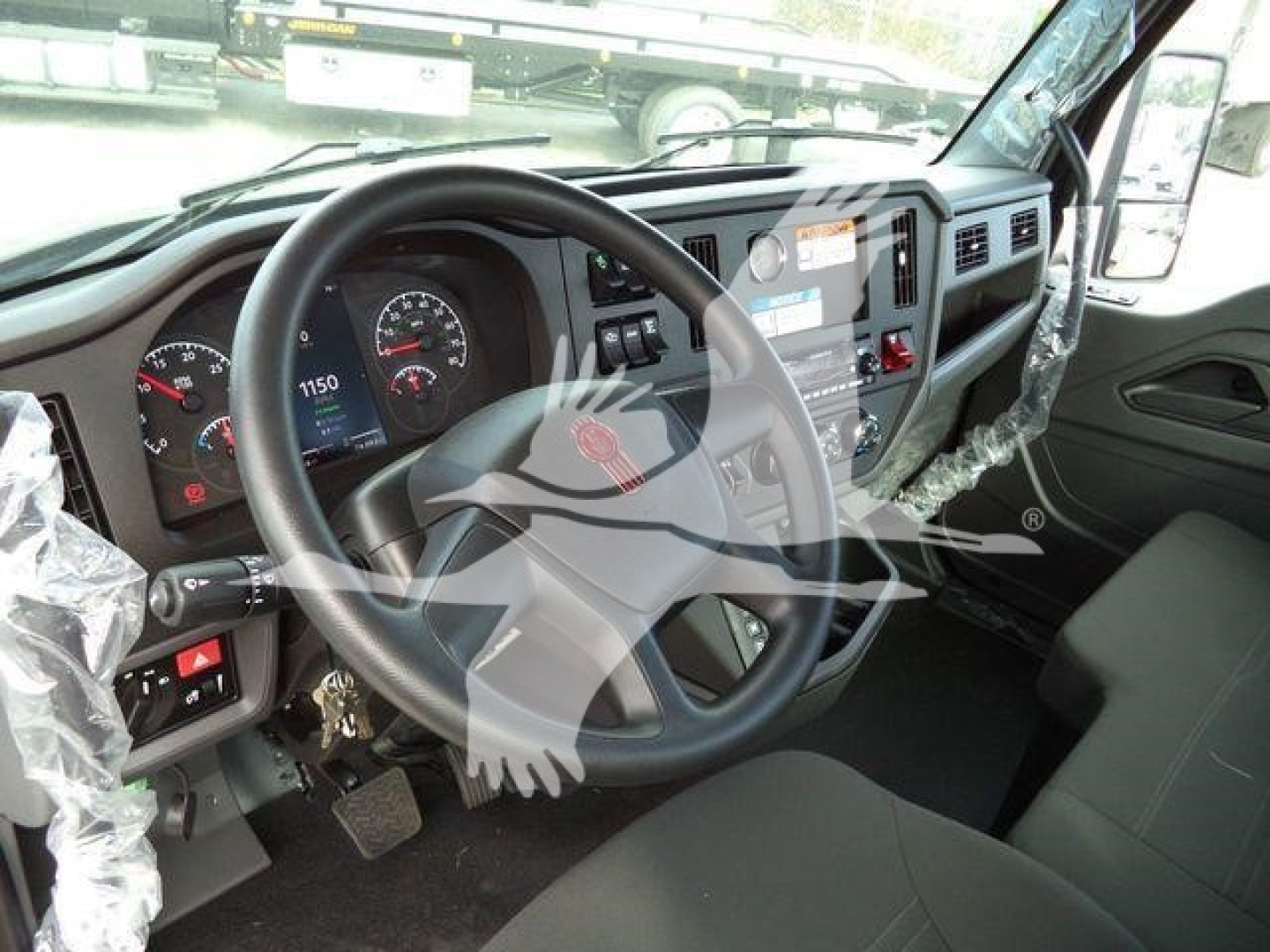 Kenworth T280 truck interior showing steering wheel, instrument cluster, and dashboard with plastic-wrapped components.