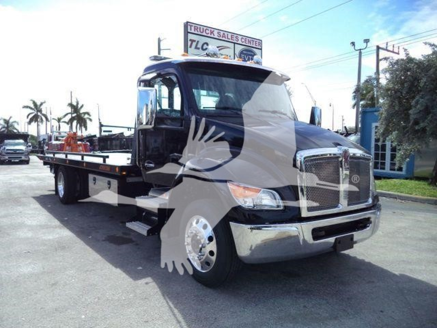 Kenworth T280 rollback truck in black, front-right view showing cab and flatbed.