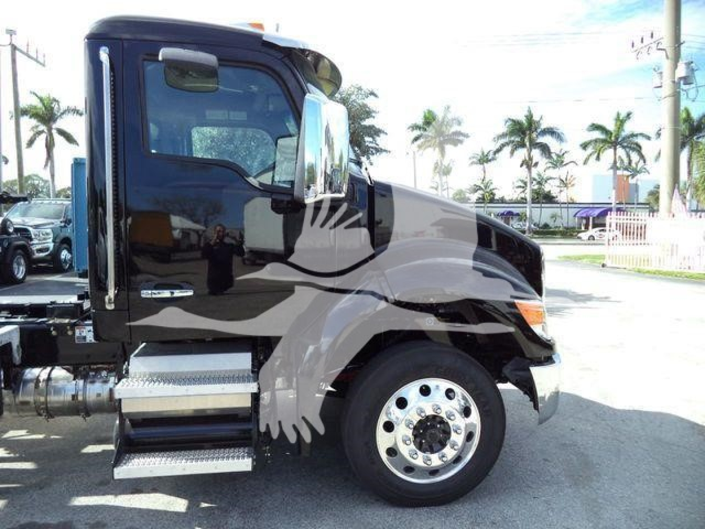Kenworth T280 rollback truck side view showing cab with black paint and chrome fuel tanks, wheel, and running boards.