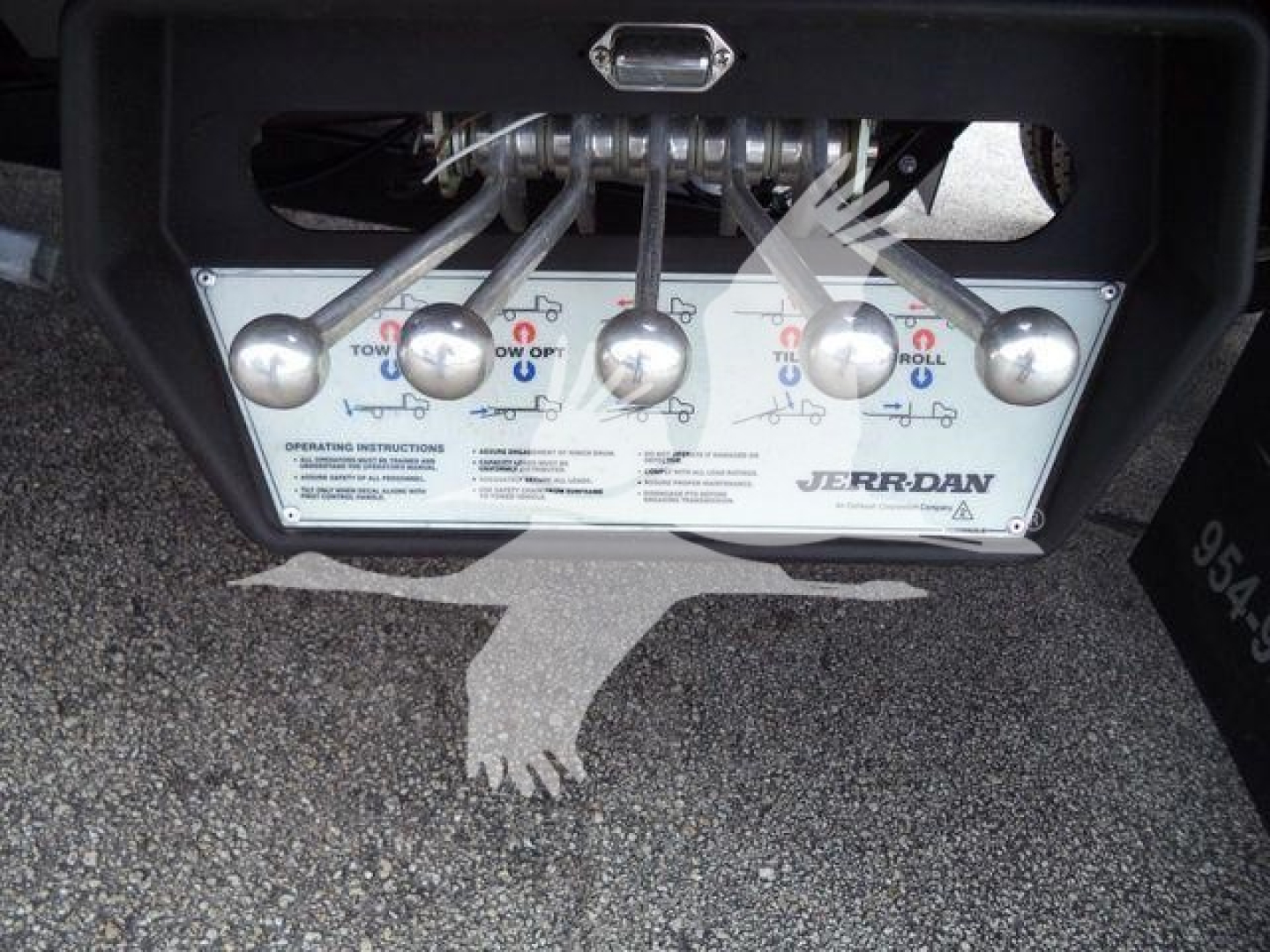 Trailer hitch/boom plate with labels and controls from a rollback tow truck, Jerr-Dan brand panel with multiple levers and instructions.