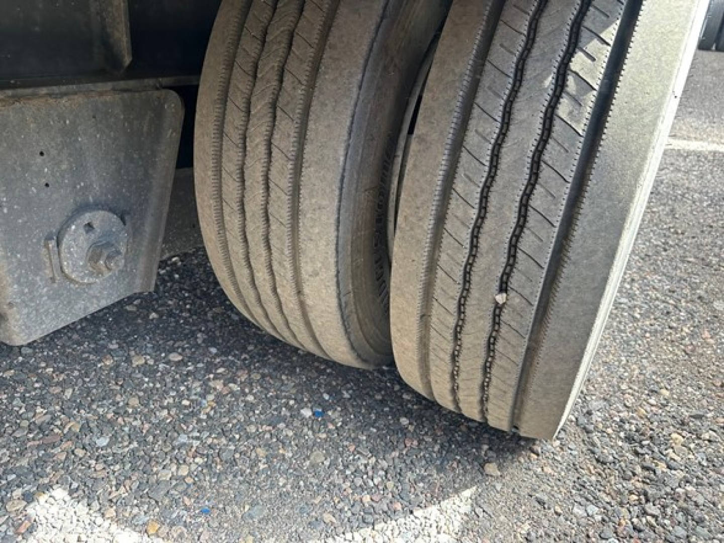 Axle area of a 2017 Great Dane steel spread air drop deck trailer showing dual tires and wheel well.