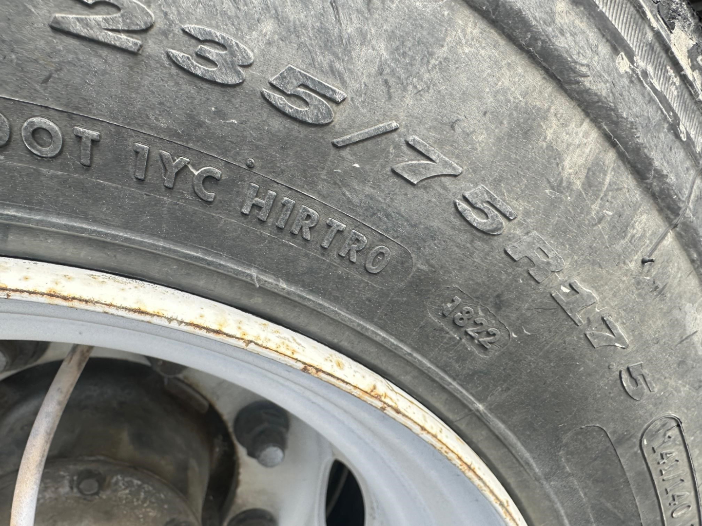 Tire sidewall with 235/75R15 size and other markings visible; part of a Great Dane spread air drop deck trailer wheel area.
