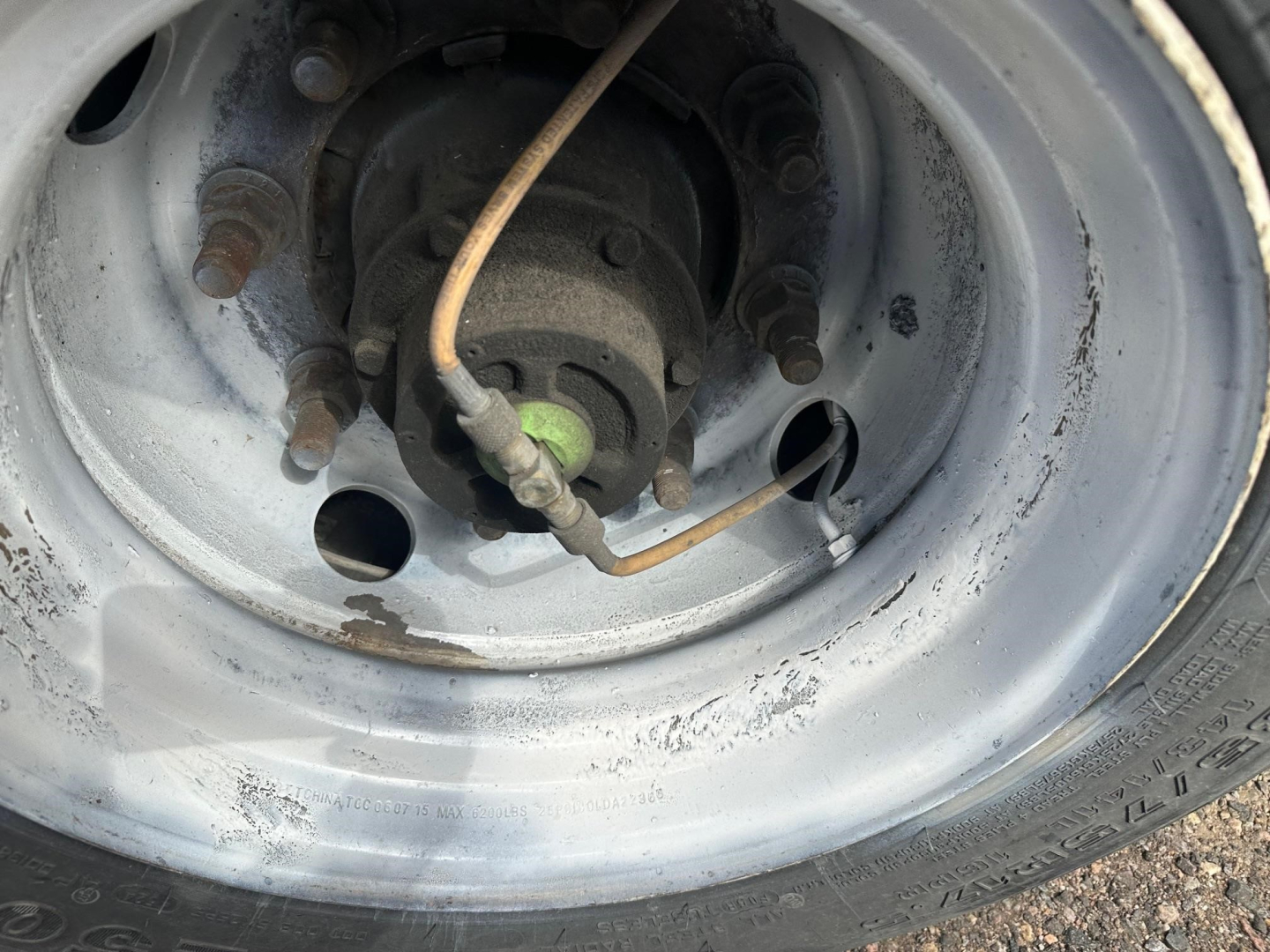 Wheel hub and rim of a 2017 Great Dane spread air drop deck trailer showing axle hub with lug studs and unknown brake components.