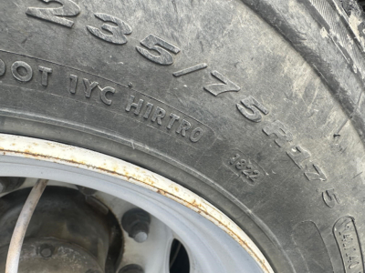 Tire sidewall with 235/75R15 size and other markings visible; part of a Great Dane spread air drop deck trailer wheel area.