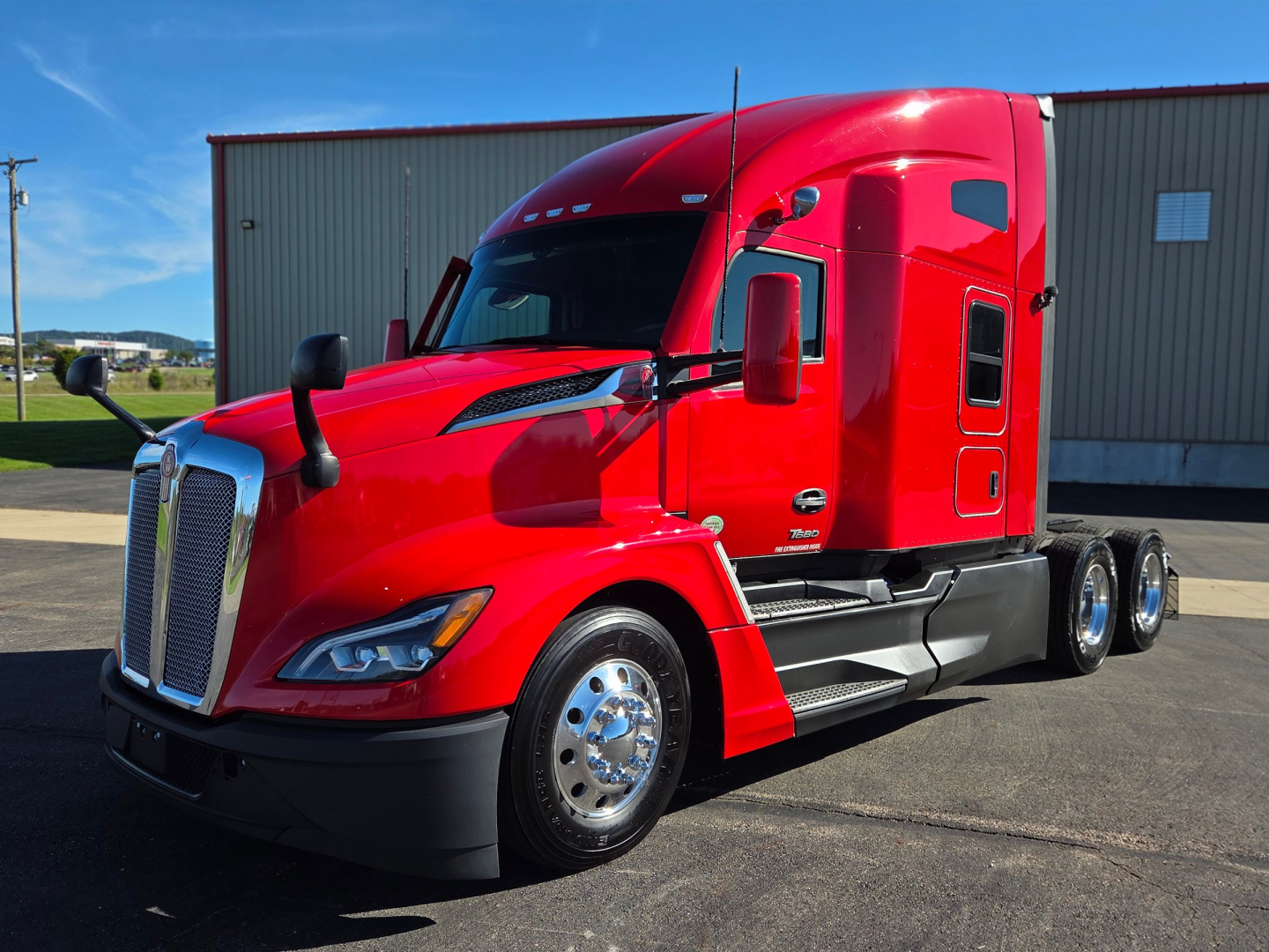 Kenworth T680 truck in red, side view showing cab, fuel tanks, chrome wheels, and dual rear axles.