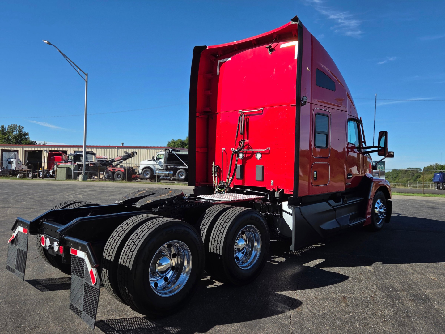 Kenworth T680 tractor rear view showing dual rear axles and red sleeper cab.