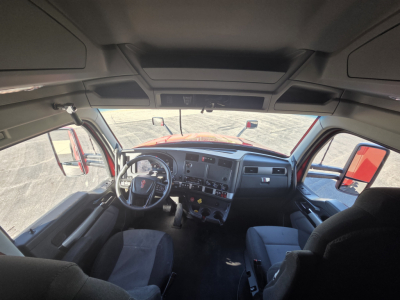 Kenworth T680 cab interior view showing steering wheel, dashboard, and driver's seat.