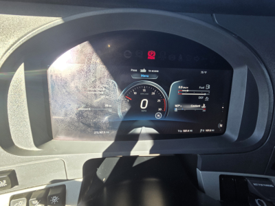 Kenworth T680 dashboard cluster showing digital gauges in a truck cockpit with 0 MPH, fuel, DEF, coolant indicators visible.
