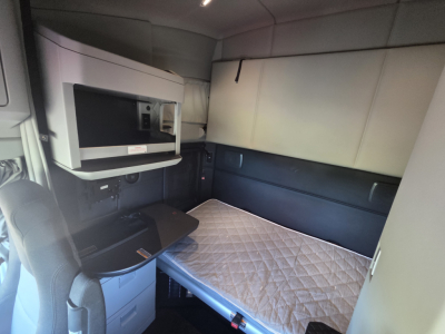 Kenworth T680 sleeper cab interior with bed and overhead storage visible
