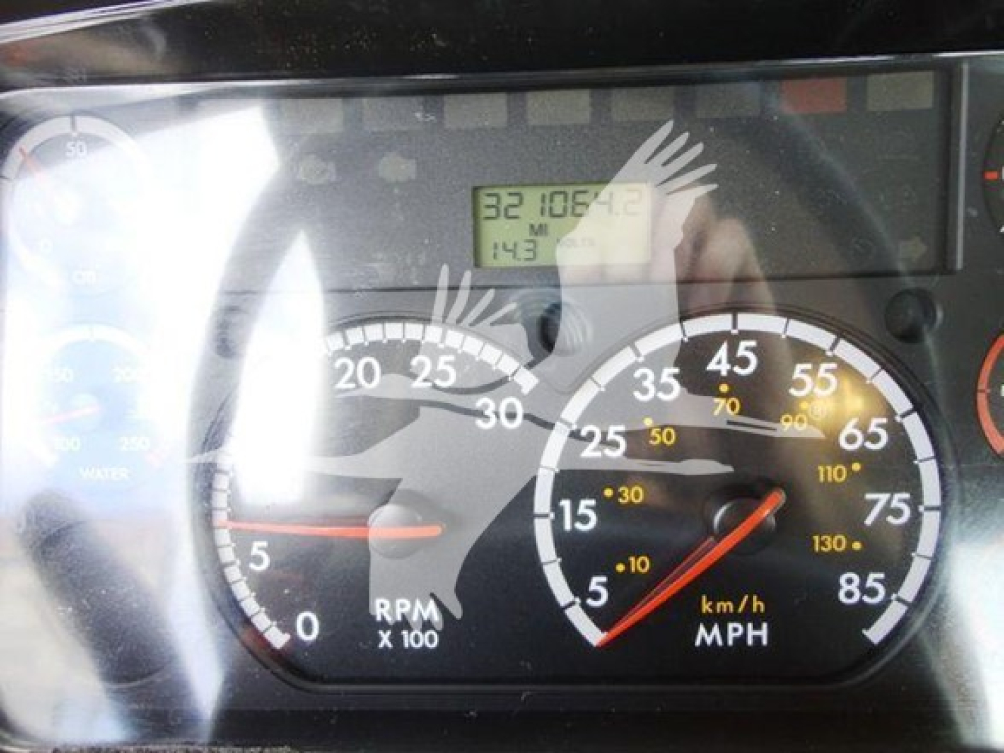 Dashboard view of a Freightliner M2 106 truck showing speedometer and tachometer with digital readout in the center; RPM 0, mph scale, odometer area and indicator gauges visible.
