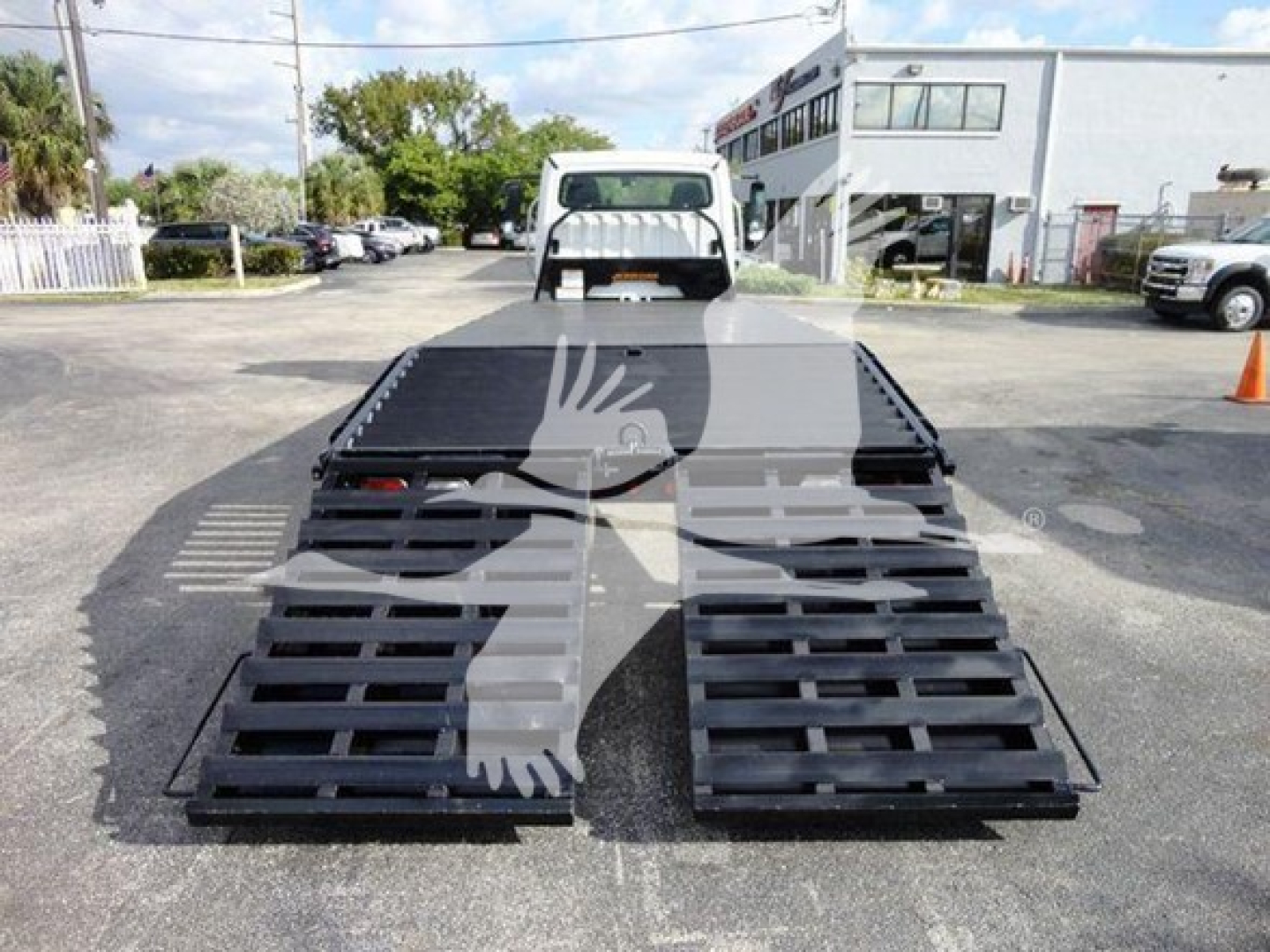 Flatbed truck with lowered ramps at the rear; 2015 Freightliner M2 106 equipment listing. Visible text on image not legible; VIN and stock not shown in image.