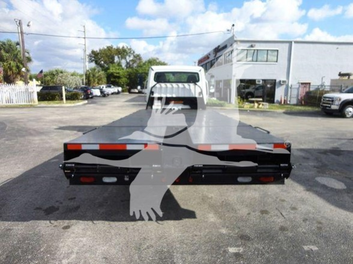 Flatbed truck bed of a 2015 Freightliner M2 106 viewed from rear, with reflective lights and metal frame.