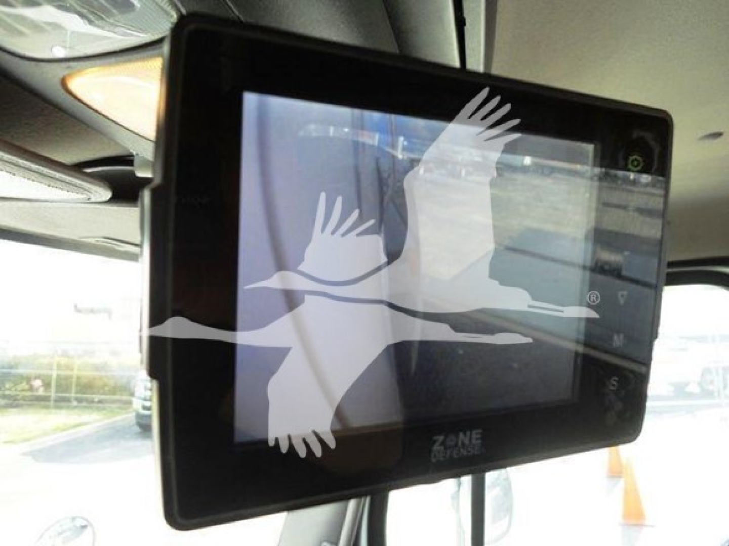 Flatbed truck cab interior showing a Zone Defense monitor screen mounted near the windshield area.