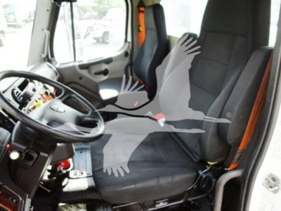 Truck cab interior of a 2015 Freightliner M2 106 showing driver seat and passenger seat with steering wheel and dashboard area.