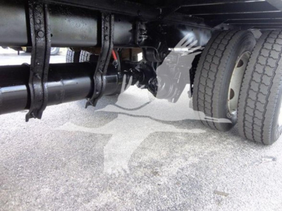 Freightliner M2 106 undercarriage showing drivetrain and dual rear wheels with suspension components visible.