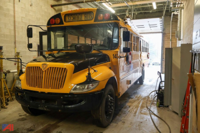 School bus front and side view in a garage with yellow and black livery, CE Series 2017 IC Corporation, bus number 14x