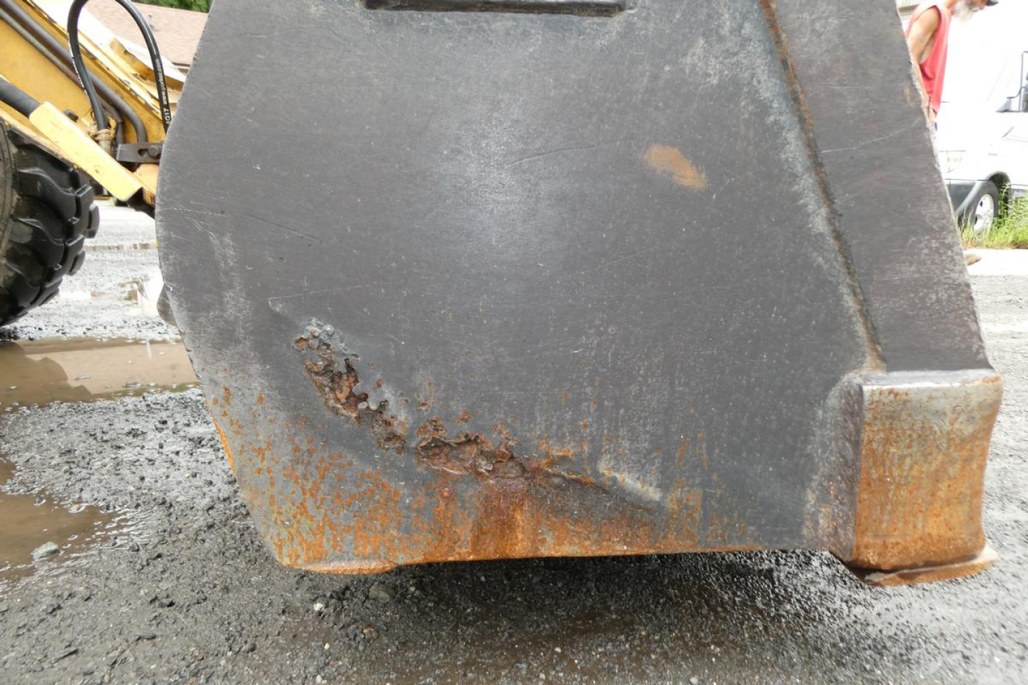 Caterpillar 902 wheel loader bucket edge with rust and wear visible on lower lip.