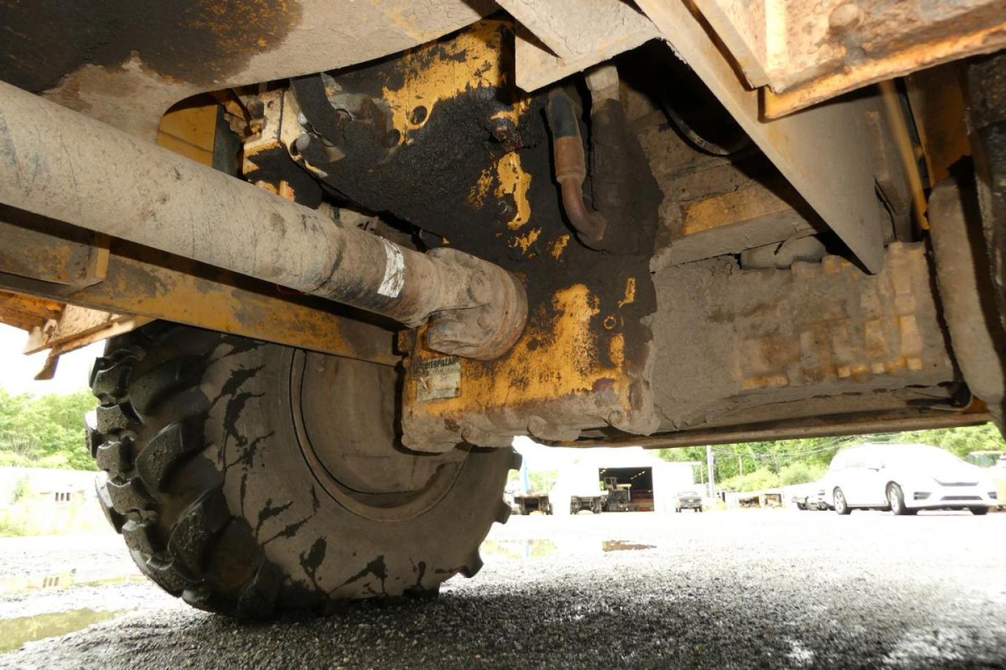 Caterpillar 902 wheel loader undercarriage showing rugged tire and hydraulic components.