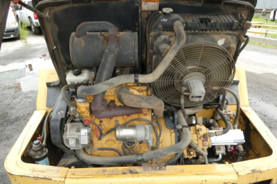 Caterpillar 902 engine bay showing radiator, hoses, belts, and exposed engine components.