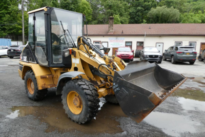 Caterpillar 902 wheel loader in service showing front bucket and cab, used equipment.