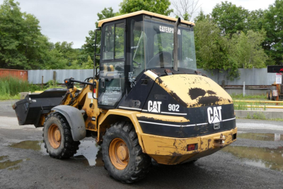 Caterpillar 902 wheel loader in service showing CAT branding and model number 902 on the side with a front bucket attachment.