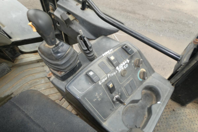 Caterpillar 902 wheel loader cab interior showing joystick controls and dashboard with switches and levers.