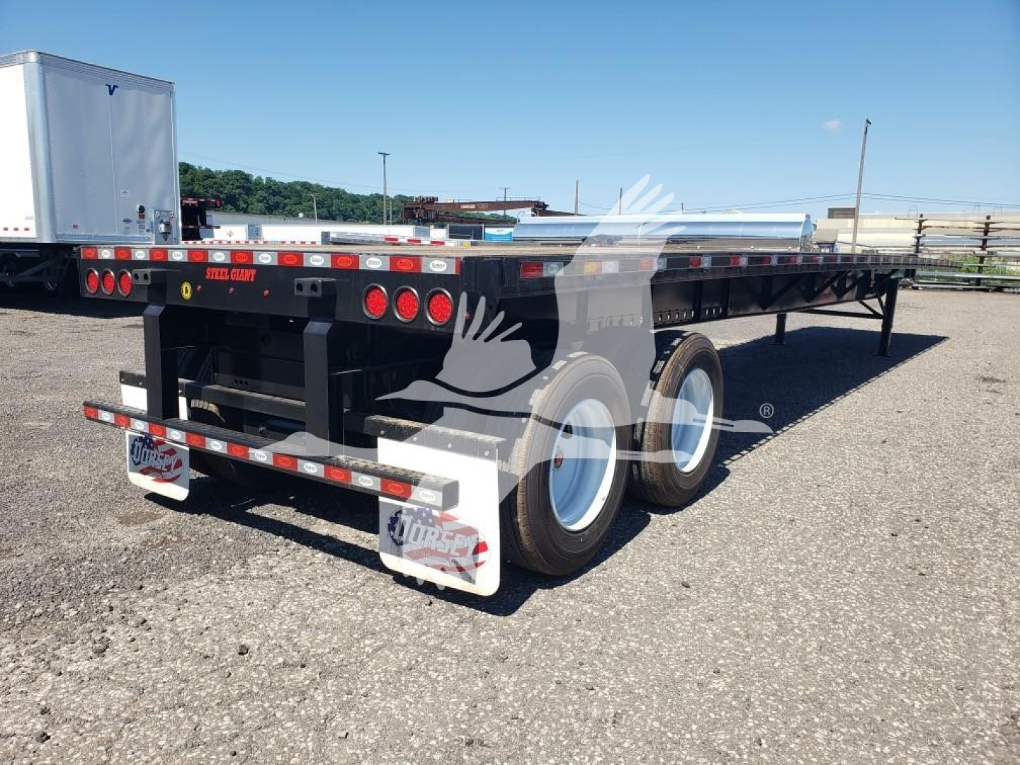 Flatbed trailer rear view showing dual rear axles with white wheels and black frame, licensing lights, rear bumper, and Dorsey branding on reflectors.