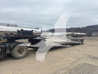 Trailer deck and hitch area of a 2007 XL Specialized XL80MDE trailer, double drop expandable, with rear wheels and a tractor-tiller unit attached; visible text on stock tag and VIN partially readable.