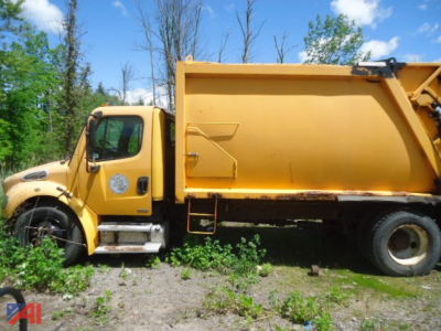 Freightliner M2 106 refuse truck side view showing large yellow hopper and cab in outdoor scenery.