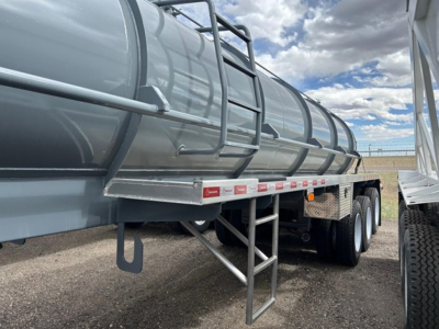 Dragon Tri Axle Air Ride trailer with cylindrical tank/haul design, side ladder, dual rear axles, grey paint, and reflective tape along side.