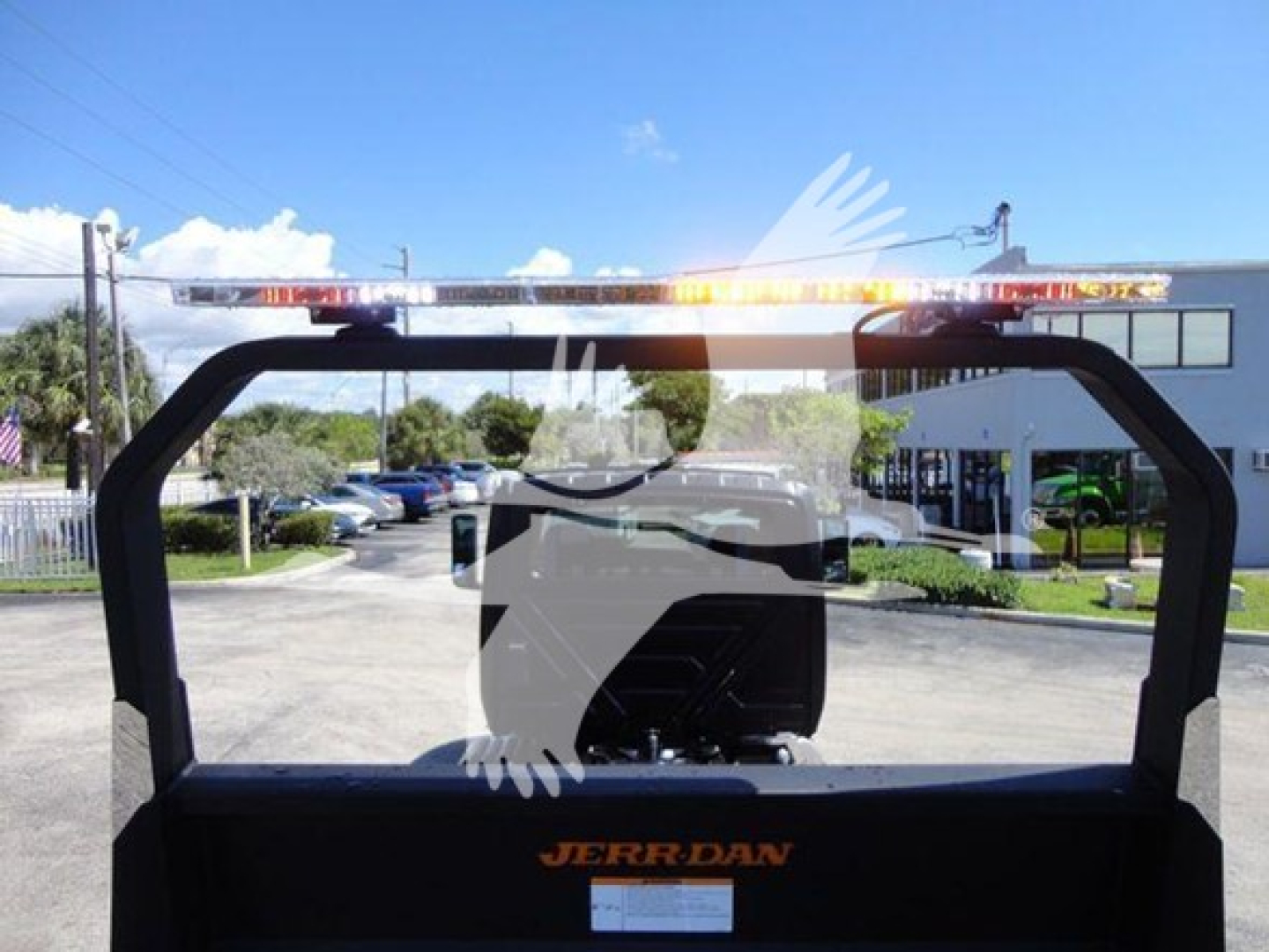 Rear view of a 2022 International MV rollback truck with an orange JERR-DAN logo on the bed and warning lights on top of the rack.