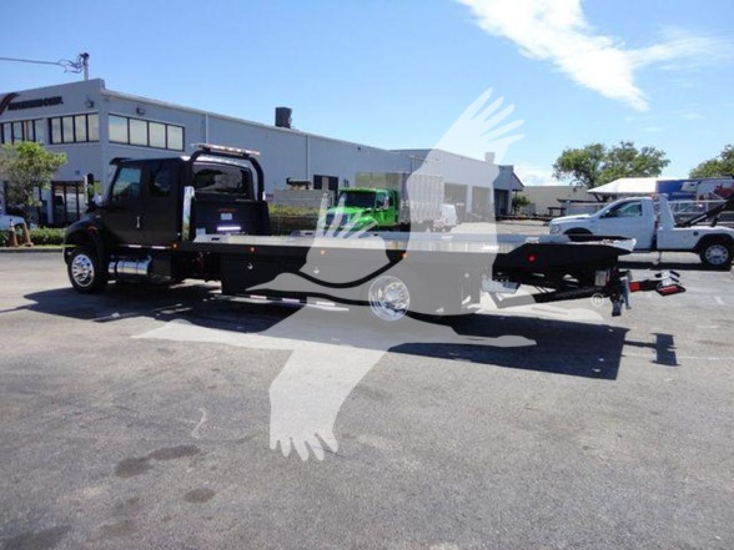 2022 International MV rollback tow truck in lot showing flatbed and cab with VIN 1HTEUMML7NH043803 on the listing image