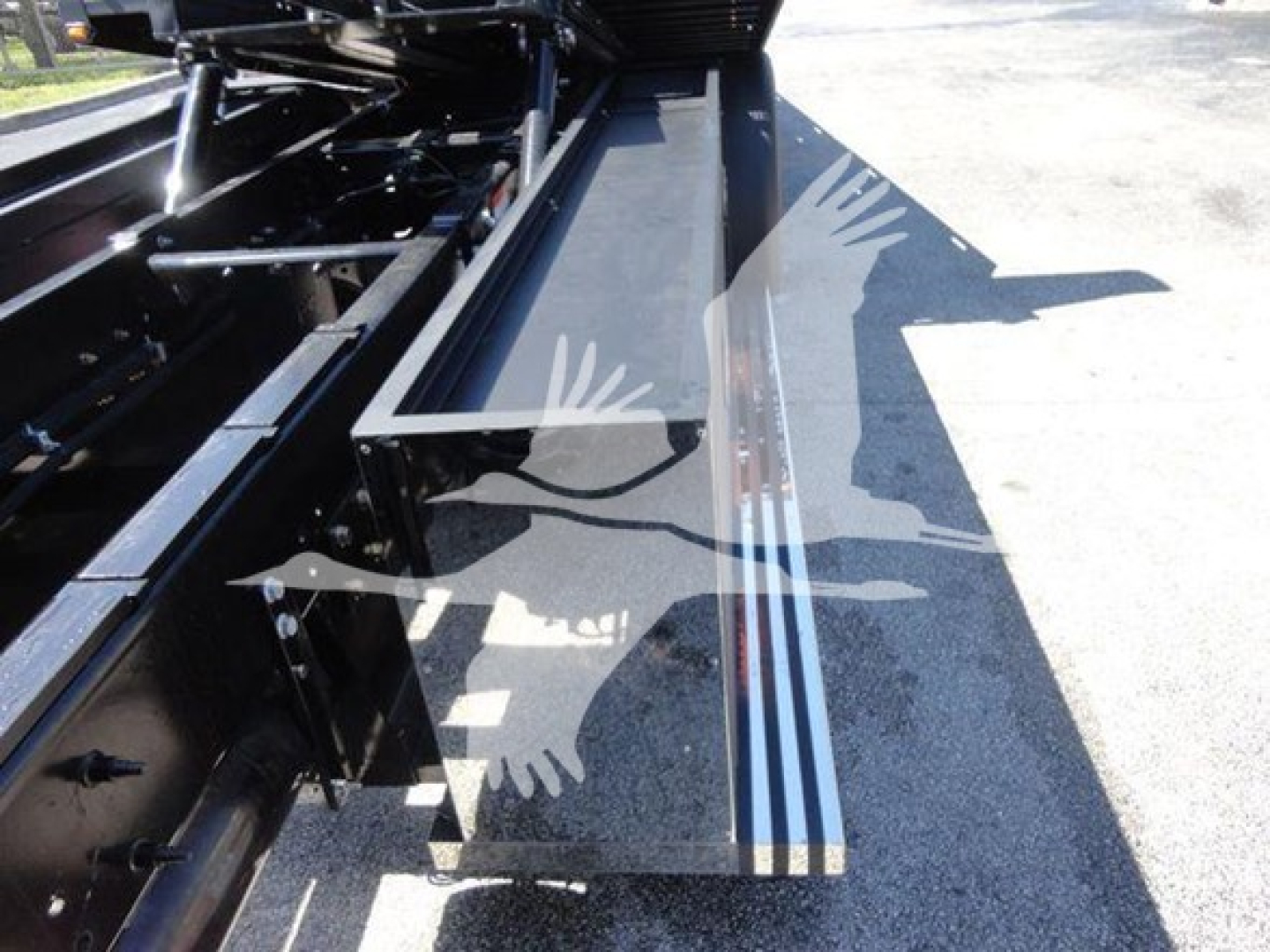 Truck rollback body with steel steps and hydraulic machinery visible in the bed area; metallic rails and support brackets present.