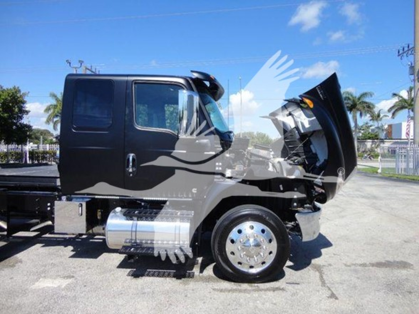 Truck cab in service showing front with hood open and engine bay visible.
