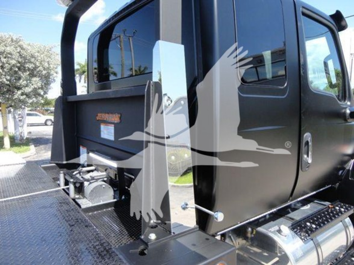 Truck cab rear and side with 'Jerr-Dan' label on black equipment, platform and hydraulic components visible near rear cab.