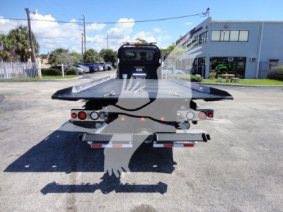Back view of a 2022 International MV rollback tow truck showing flatbed and rear lights.