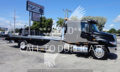 International MV rollback truck with a flatbed, black cab, and chrome wheels, VIN 1HTEUMML7NH043803 visible on listing image.