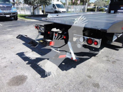 Truck rollback bed with hydraulic ramps and dual taillights, back view showing platform and towing apparatus.
