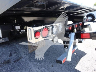 Trailer hitch area of 2022 International MV rollback truck showing rear lights, bumper, and support structure with hydraulic lines and wiring; license plate area not visible.