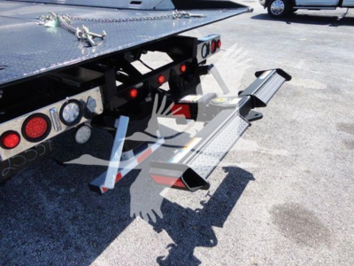 Truck rollback equipment showing rear steps and mounting hardware with loading ramps attached.