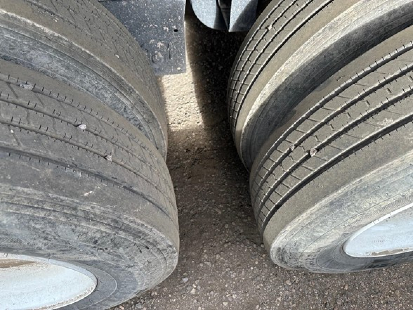Tandem axle trailer tires with worn tread visible, no other identifiable text.